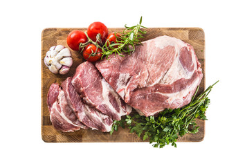 Pork neck raw meat with garlic parsley herbs tomatoes and rosemary on butcher board isolated on white background