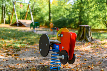 Children's playground in Germany with various rocking swings and a zip-line in the background.