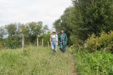 Fototapeta na wymiar Couple of farmers walking in field