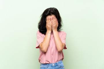 Young woman over isolated green background with tired and sick expression