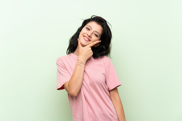 Young woman over isolated green background smiling