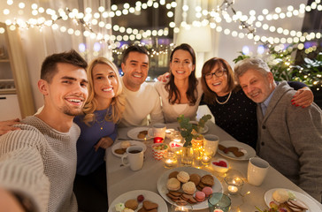 celebration, holidays and people concept - happy family having tea party at home and taking selfie