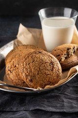 Chocolate chip cookies with milk on black table. Copy space.