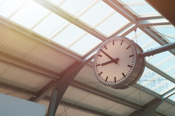 White round clock installed at the top near the glass roof at train station for decoration interior and showing time to passengers Time management and ceiling structure concept - Powered by Adobe