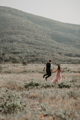 Beautiful wedding couple, bride and groom, in love on the background of mountains