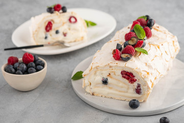 Meringue roll cake with cream and raspberries. Roulade, summer dessert, closeup.