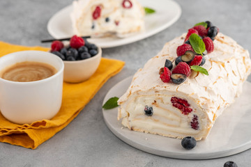 Meringue roll cake with cream and raspberries. Roulade, summer dessert, closeup.