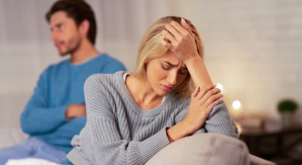 Depressed Wife Sitting Next To Indifferent Husband At Home, Panorama