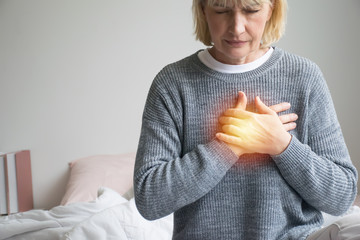 woman experiencing discomfort in his chest.Heart attack with woman clutching his chest.Severe...