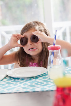 A little girl at her kitchen table having a healthy snack