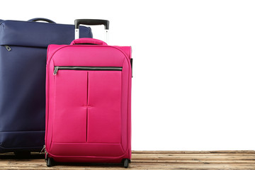Blue and pink suitcases on wooden table