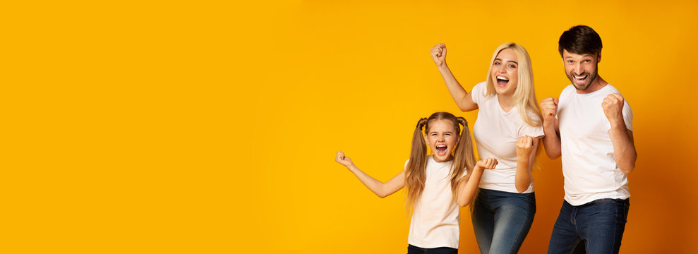 Family Of Three Shaking Fists Gesturing Yes, Yellow Background, Panorama