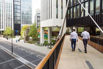 In the city of London office workers walk along a new section of the elevated walkway or so called pedway that was constructed in 2017 along and above London Wall road and Tower Of St Elsyng Spital © Harry Green
