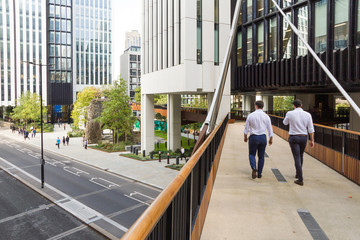 In the city of London office workers walk along a new section of the elevated walkway or so called...