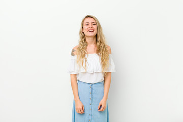 young blonde woman with a big, friendly, carefree smile, looking positive, relaxed and happy,...