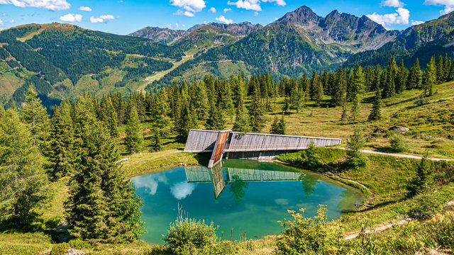 Beautiful alpine view with reflections in a pond at the famous Planai Alm, Schladming, Steiermark, Austria