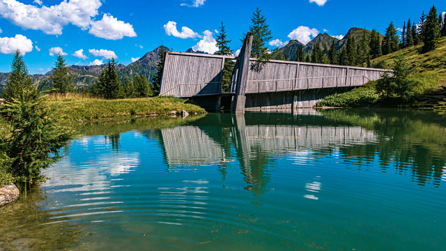 Beautiful alpine view with reflections in a pond at the famous Planai Alm, Schladming, Steiermark, Austria