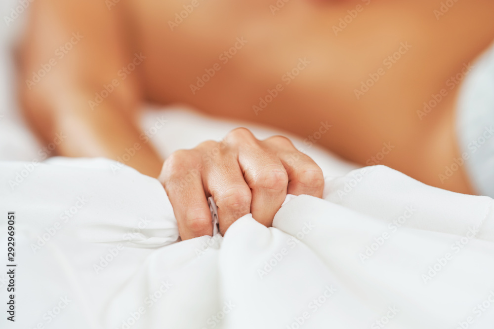 Wall mural Female hand holding bed sheet