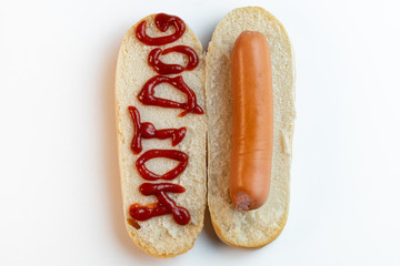 Hot dog bun with sausage on white background. The inscription ketchup Hot-dog. Top view.
