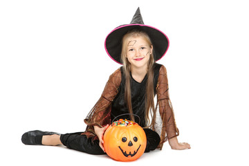 Young girl in halloween costume and pumpkin bucket with candies on white background