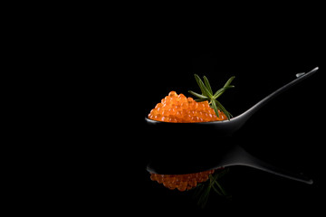 Caviar, Red Caviar in Appetizer Spoon with dill on reflecting table isolated on black background, copy space
