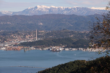 Panoramic view of La Spezia in Liguria shot from above. A cruise ship in the port, numerous moored sailboats and commercial port cranes..