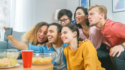 At Home Diverse Group of Friends Doing Collective Selfie, Guy Holds Smartphone People Smile, Laugh and do Duck Lips.Young People Doing Live Stream of the Home Party.