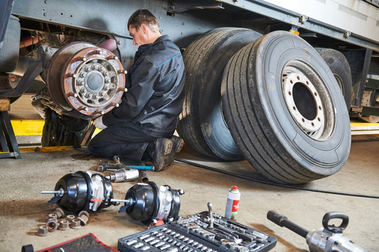 Truck repair service. Mechanic works with brakes in truck workshop