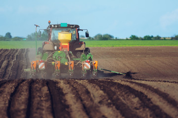 Fototapeta premium Tractor and Seeder Planting Crops on a Field