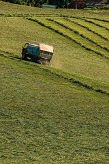 Fototapeta na wymiar Beautiful alpine view with an active agricultural vehicle at the famous Planai Alm, Schladming, Steiermark, Austria