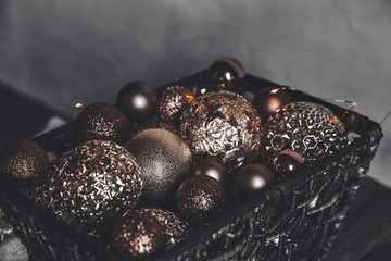 vintage christmas, new Year toys and decoration in basket on brown wooden table with garlands