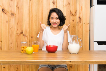 Asian young woman having breakfast milk giving a thumbs up gesture