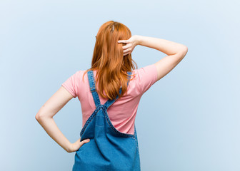 young red head pretty woman thinking or doubting, scratching head, feeling puzzled and confused,...
