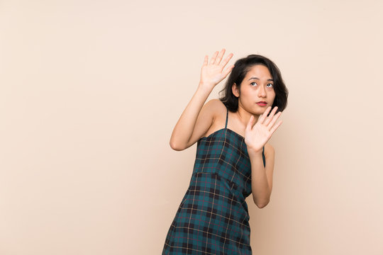 Asian young woman over isolated yellow wall nervous and scared