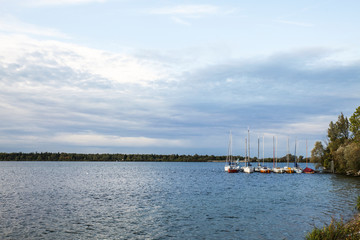 Obraz premium Sunset at the lake with anchored sailboats