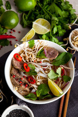 Pho Noodle Soup on dark table. Beef with Chilli, Basil, Rice Noodles, Bean Shoots showing noodles