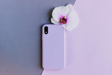 Lilac silicone case on grey and pink background. Pastel purple silicone case for smartphone....