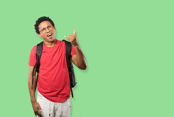 Amazed young man making a gesture of calling with the hand