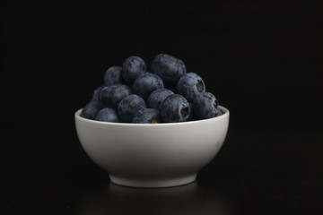 a bowl of blueberry isolated on black background