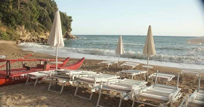 Umbrellas and beach beds in Lerici, near the Cinque Terre. A raft is parked on the seashore.