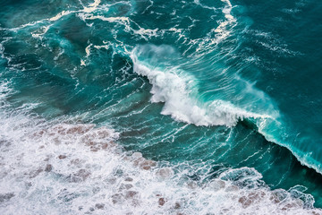 Colorful sea background. Turquoise ocean water with waves, spray and white foam.