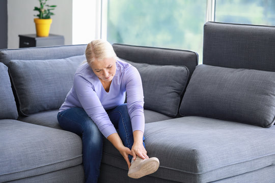 Mature Woman Suffering From Pain In Leg At Home