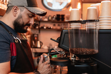 Barista in coffee shop preparing a cappuccino