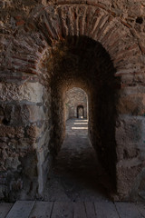 Fototapeta na wymiar View through an arched passage in a thick rampart