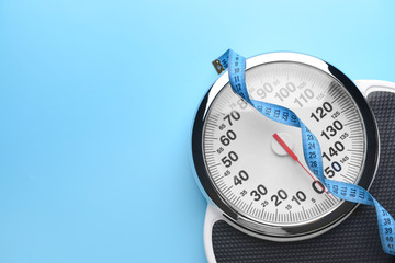 Scales and measuring tape on color background. Weight loss concept