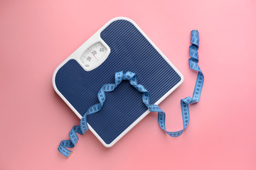 Scales and measuring tape on color background. Weight loss concept
