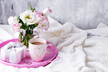 A tray with a cup of coffee, gift box, flowers and rings on the bed. Valentine's Day Wedding Offer