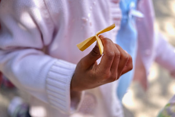 Close up of a hand of an Afro-American child holding a paper plane.