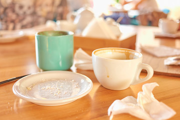 Mess on the table after coffee break with dirty plates and crumbs and cups.