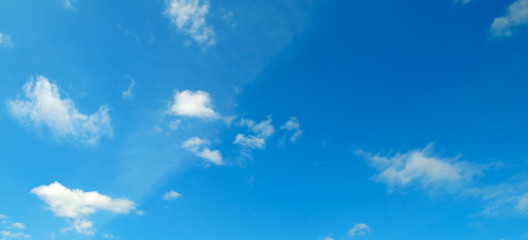 White clouds in the blue sky. Wide photo.